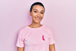 Smiling woman with short cropped hair wearing a pink t-shirt